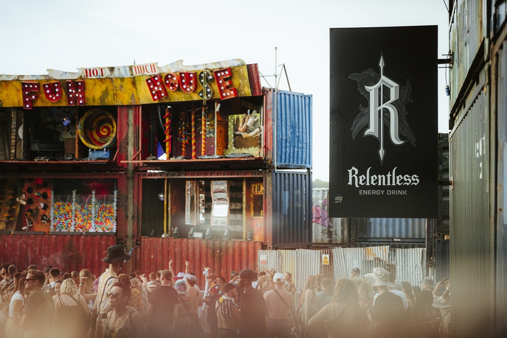 This image may contain: boomtown, james north photo, relentless, relentless energy, wrong side of the tracks, advertisement, food, sweets, person, urban, people, face, head