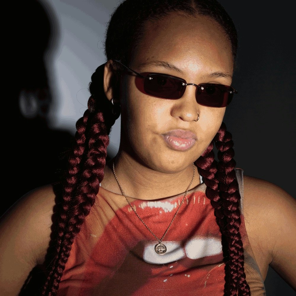 This image may contain: braid, hair, person, accessories, sunglasses, jewelry, necklace, face, head
