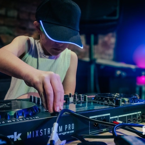 This image may contain: person, clothing, hat, dj
