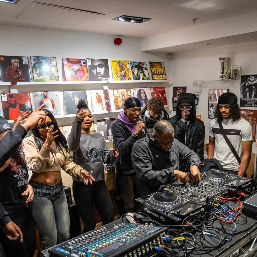 This image may contain: person, adult, female, woman, male, man, hat, glasses, book, handbag