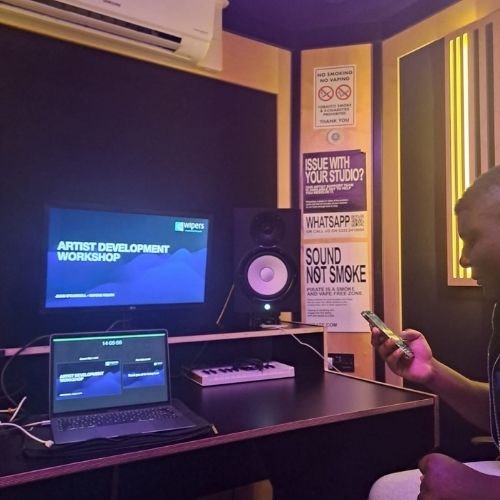 This image may contain: speaker, table, desk, computer, laptop, person, mobile phone, computer hardware, monitor, screen