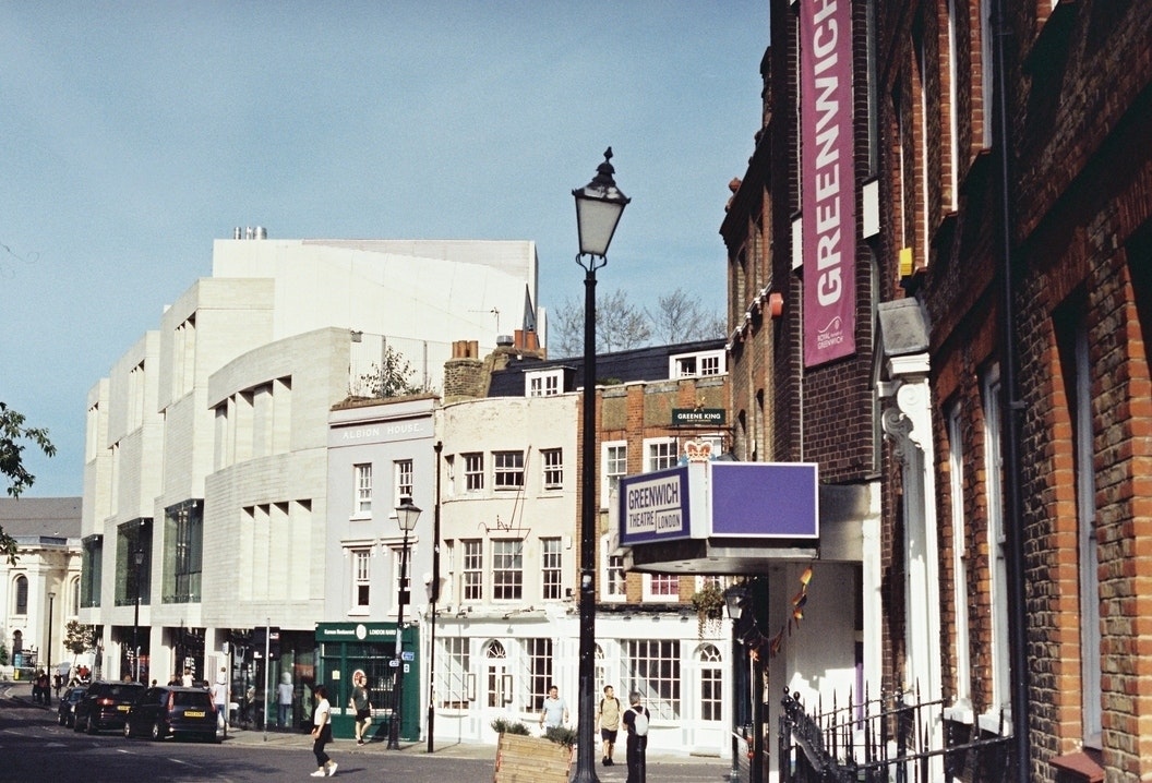 This image may contain: city, road, street, urban, neighborhood, metropolis, person, downtown, condo, car