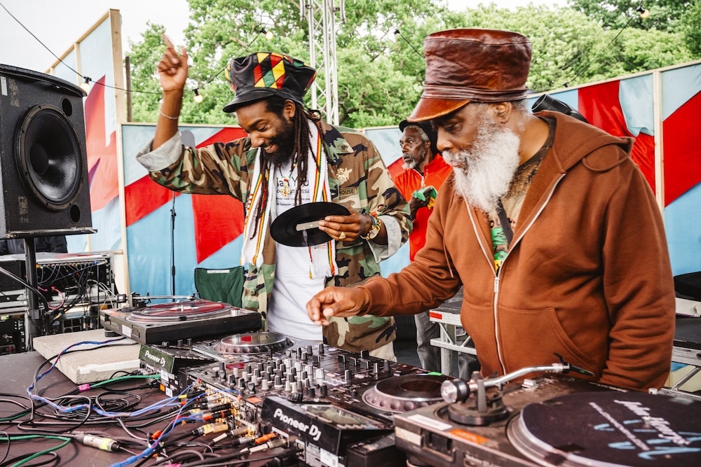 This image may contain: electronics, speaker, adult, male, man, person, clothing, hat, dj, wristwatch