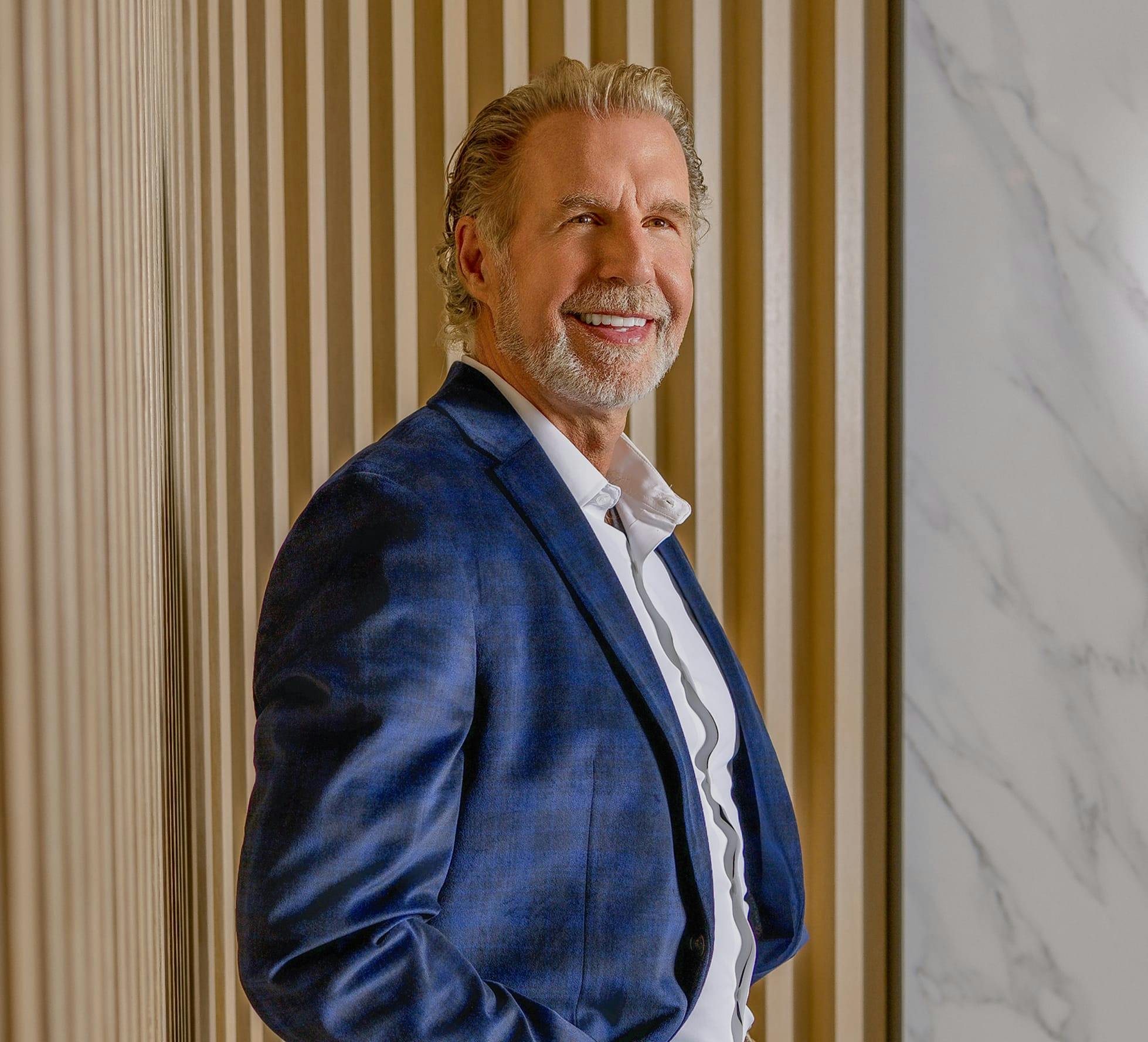 Dr Paul O'Malley in a suit, standing