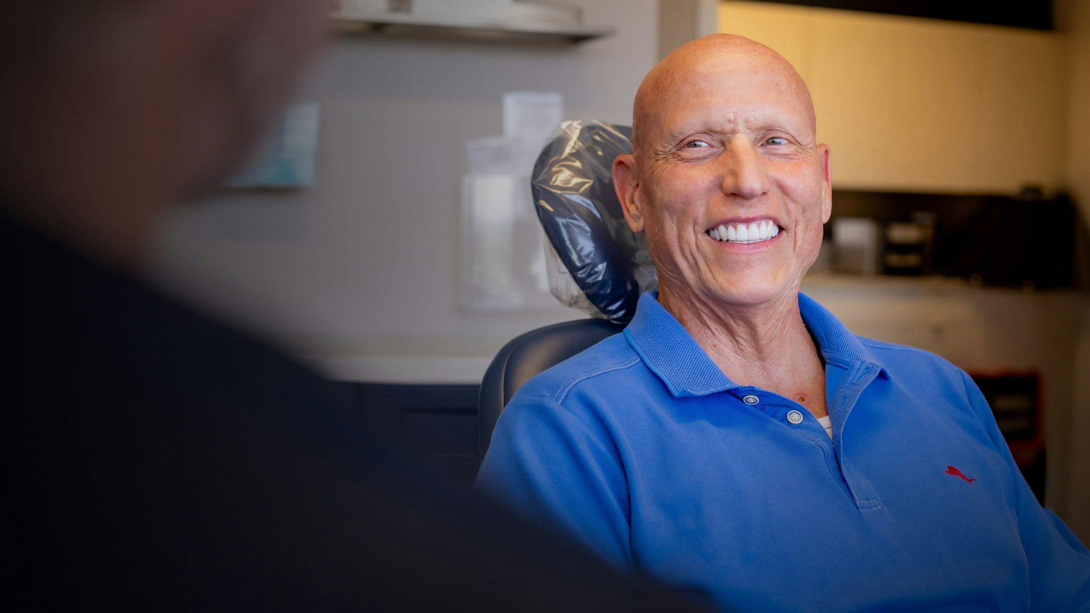 Man sitting in patient chair, smiling