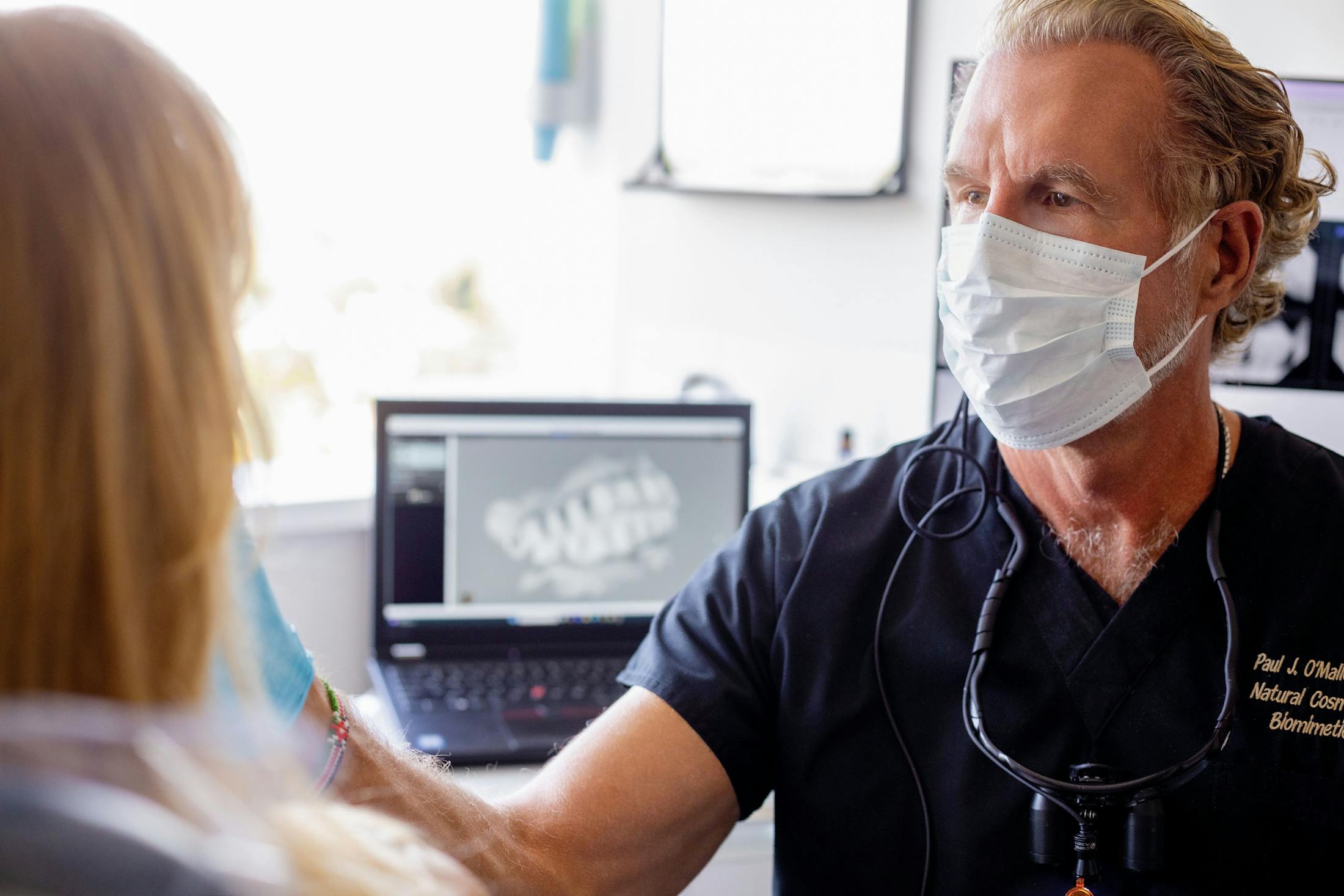 Dr. Paul O'Malley looking at patient's teeth