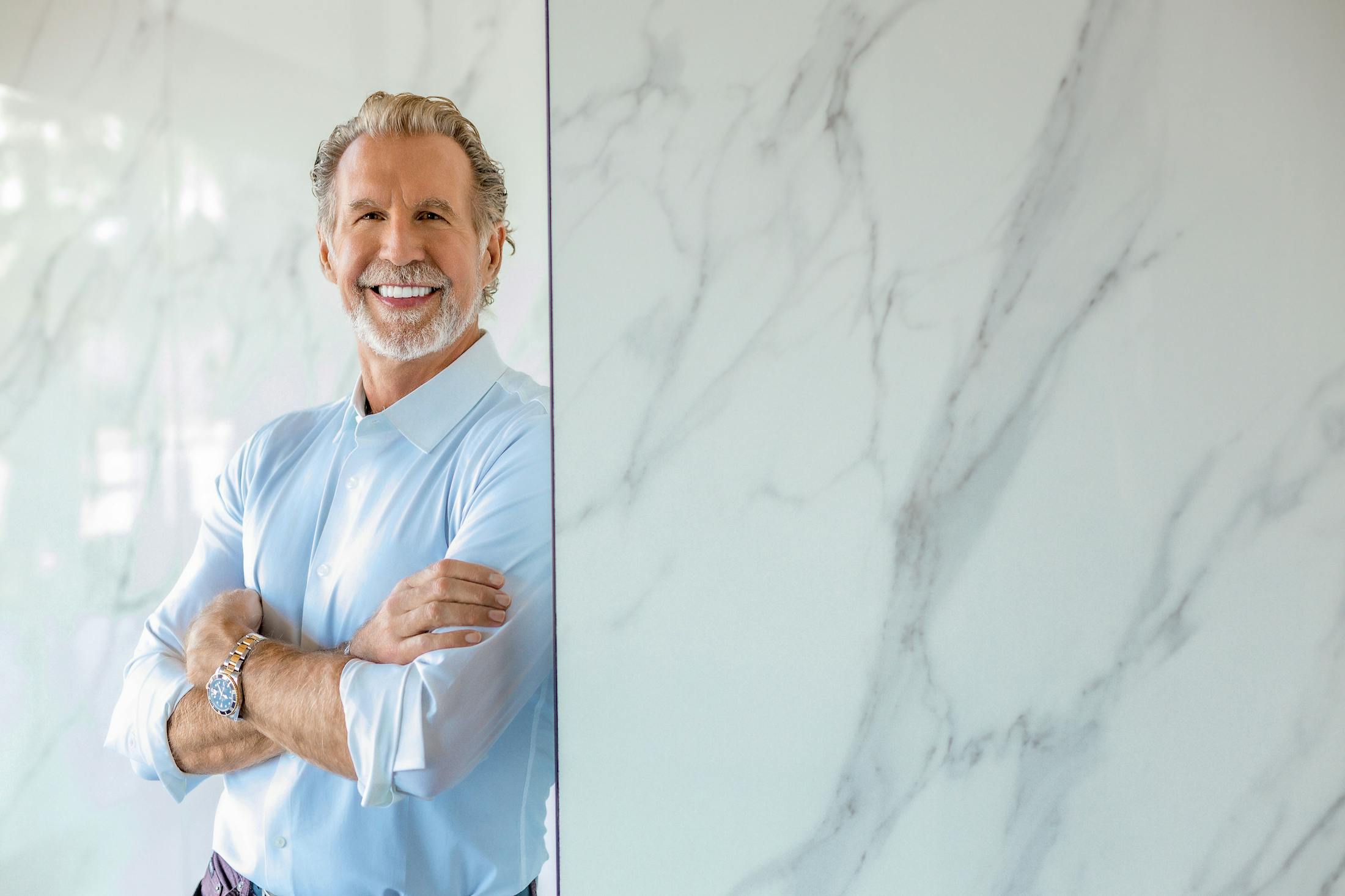 Dr. Paul O'Malley smiling and leaning against wall