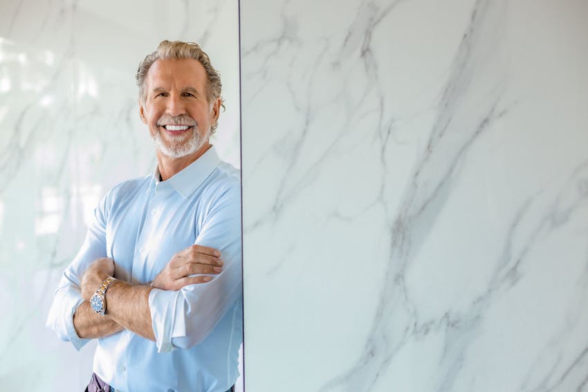 Dr. Paul O'Malley smiling and leaning against wall