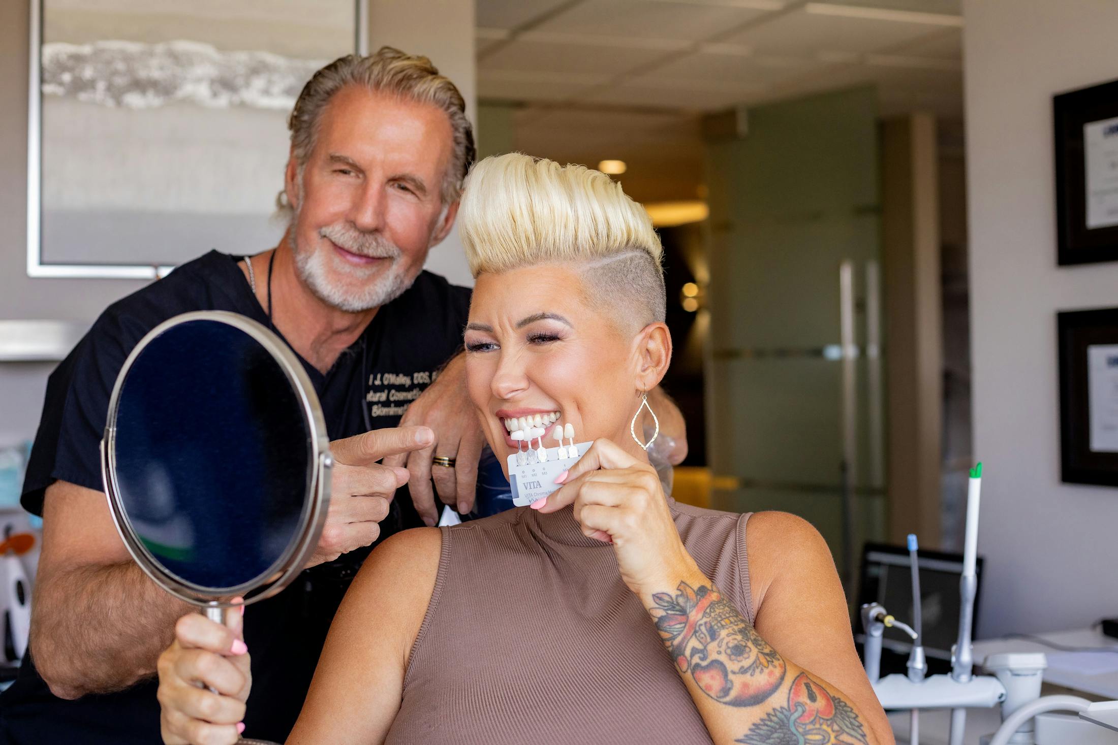 woman testing the whitness of her teeth with Dr. Paul O'Malley