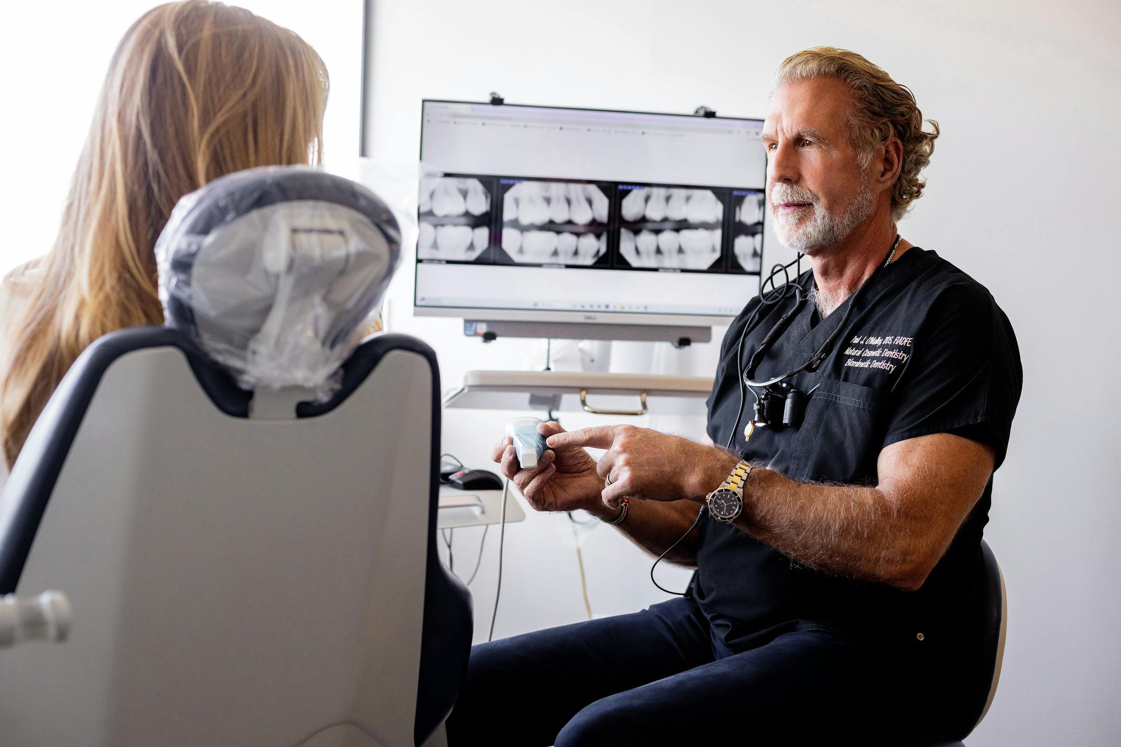 Dr. Paul O'Malley explaining x-rays to patient