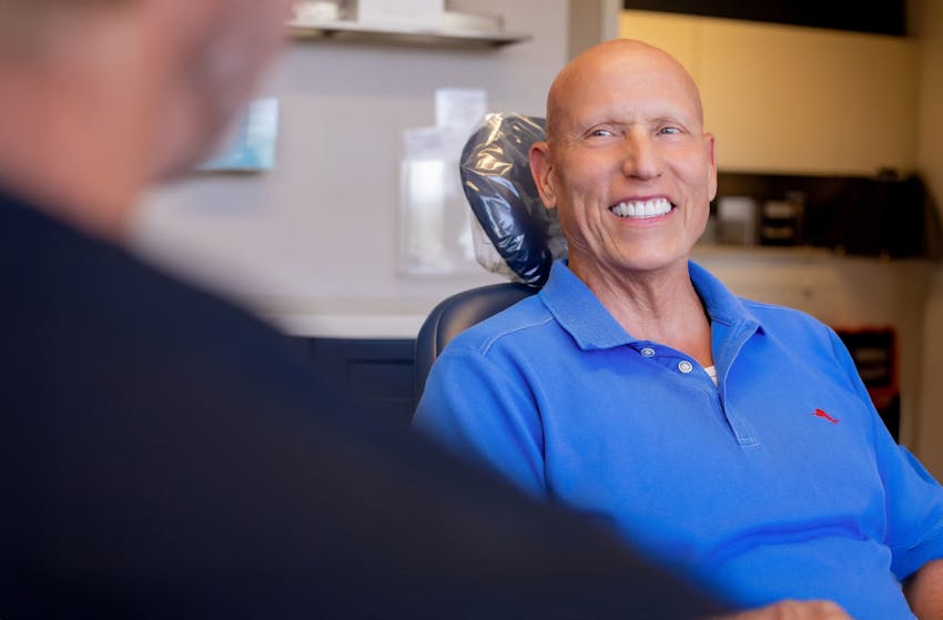 male patient smiling in exam chair