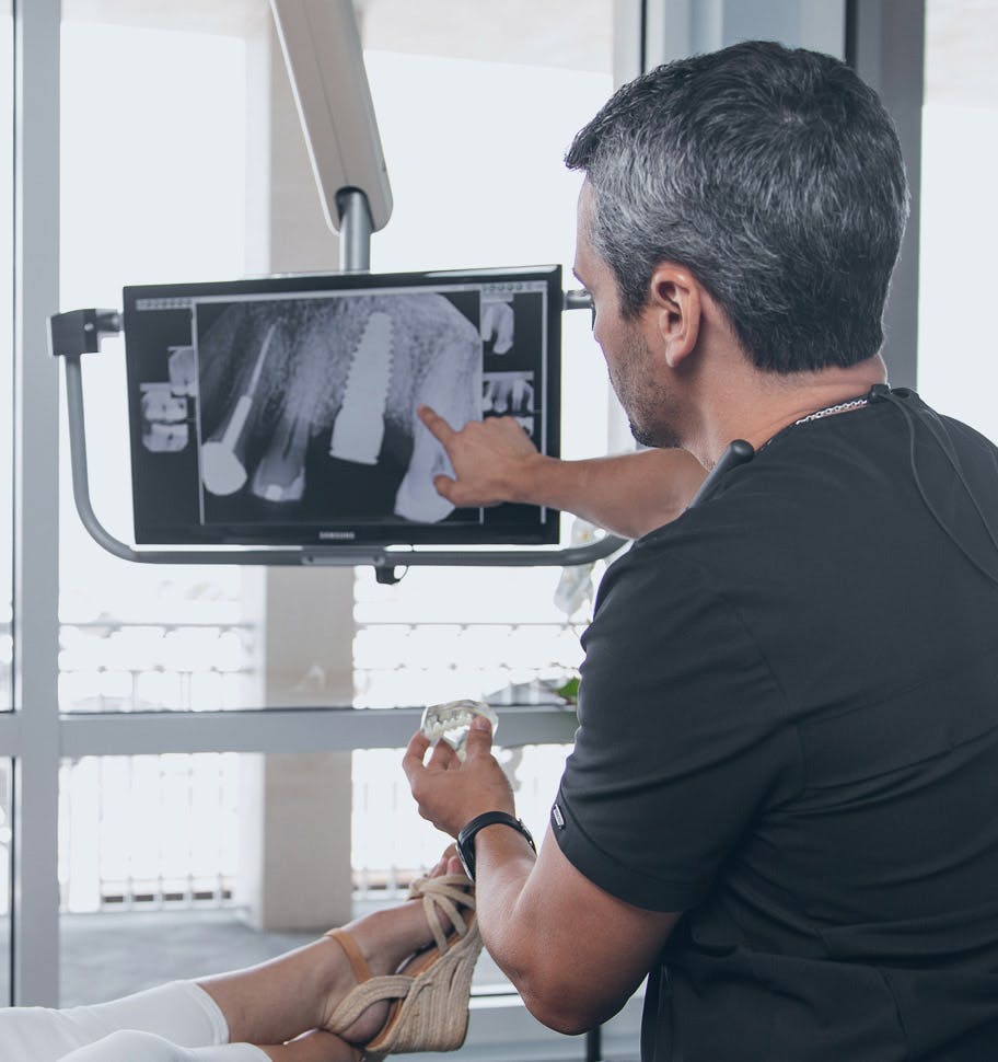 staff member pointing to x-ray on screen