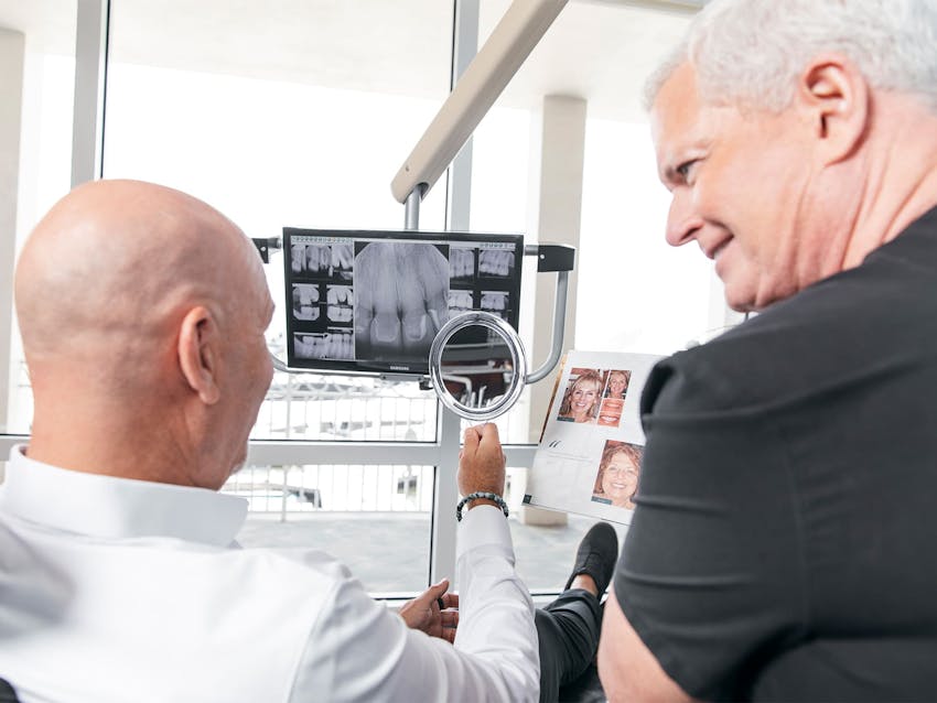 staff member showing patient his x-rays of his teeth
