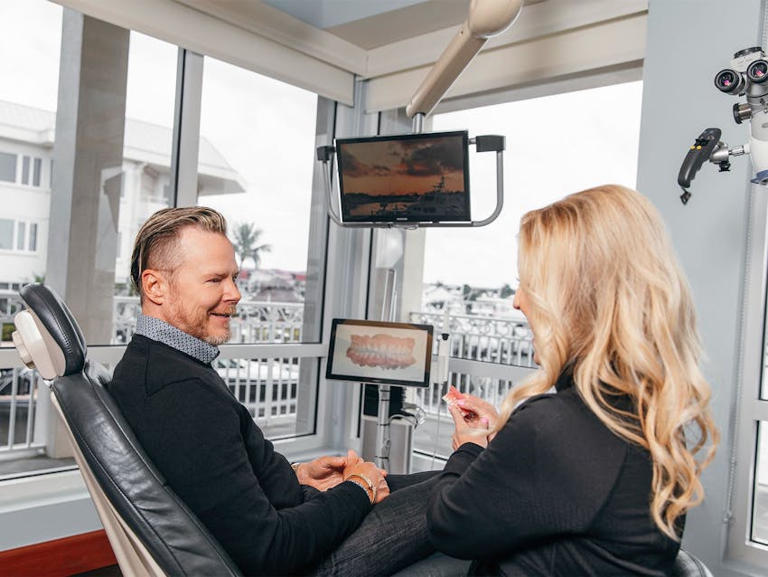 male patient talking to staff member with his 3-D x-ray is on the screen