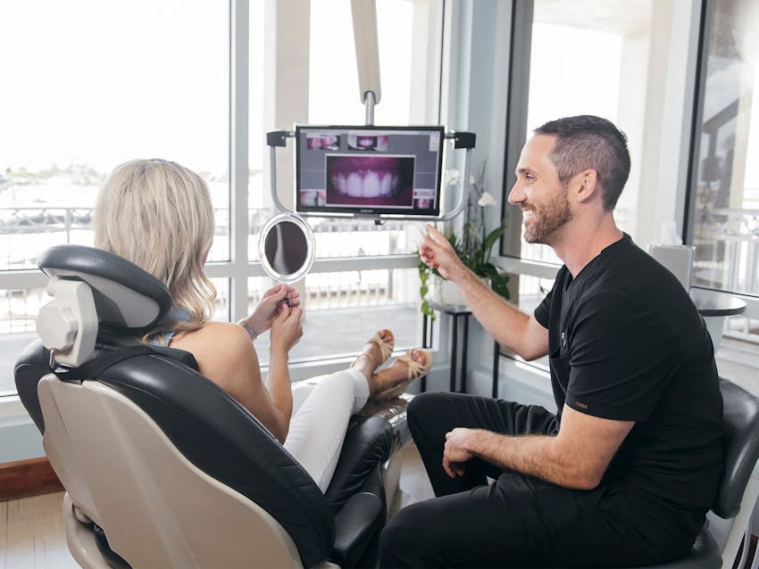 staff member showing patient up close images of her teeth on the screen