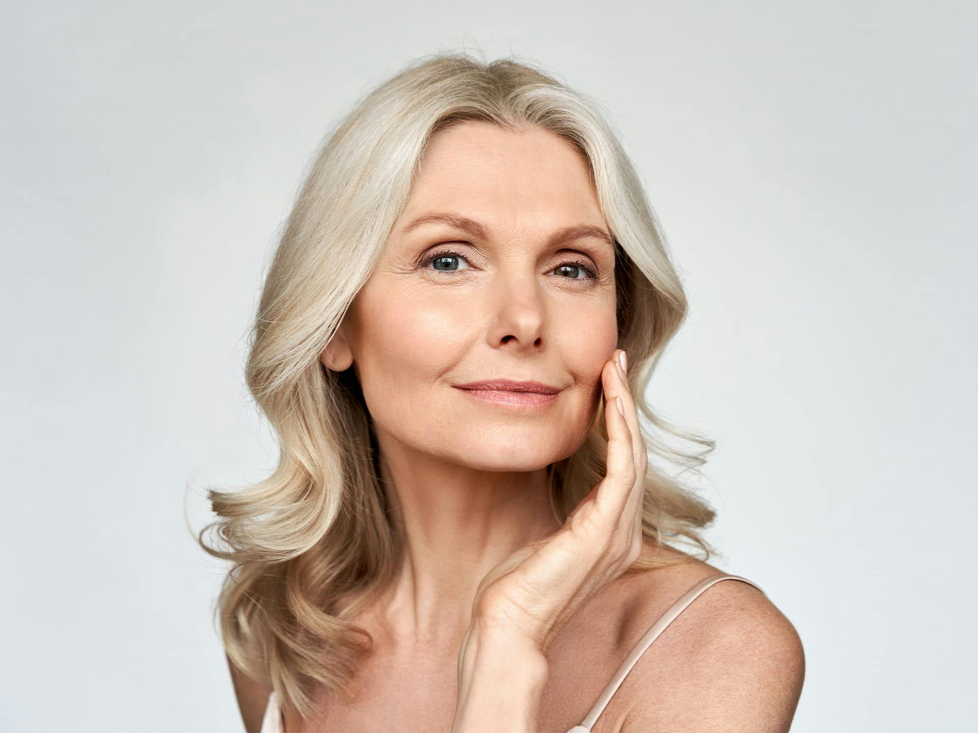 woman looking forward and touching her cheek