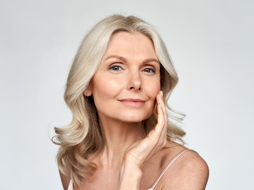 woman looking forward and touching her cheek