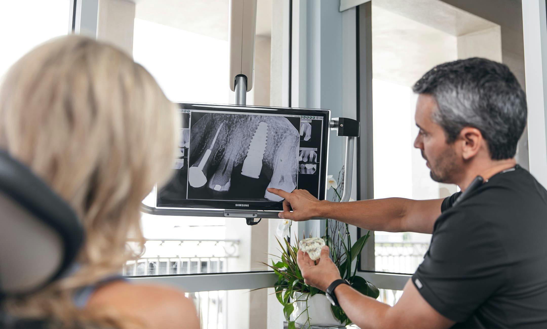 staff member pointing to screen to show patient her x-ray