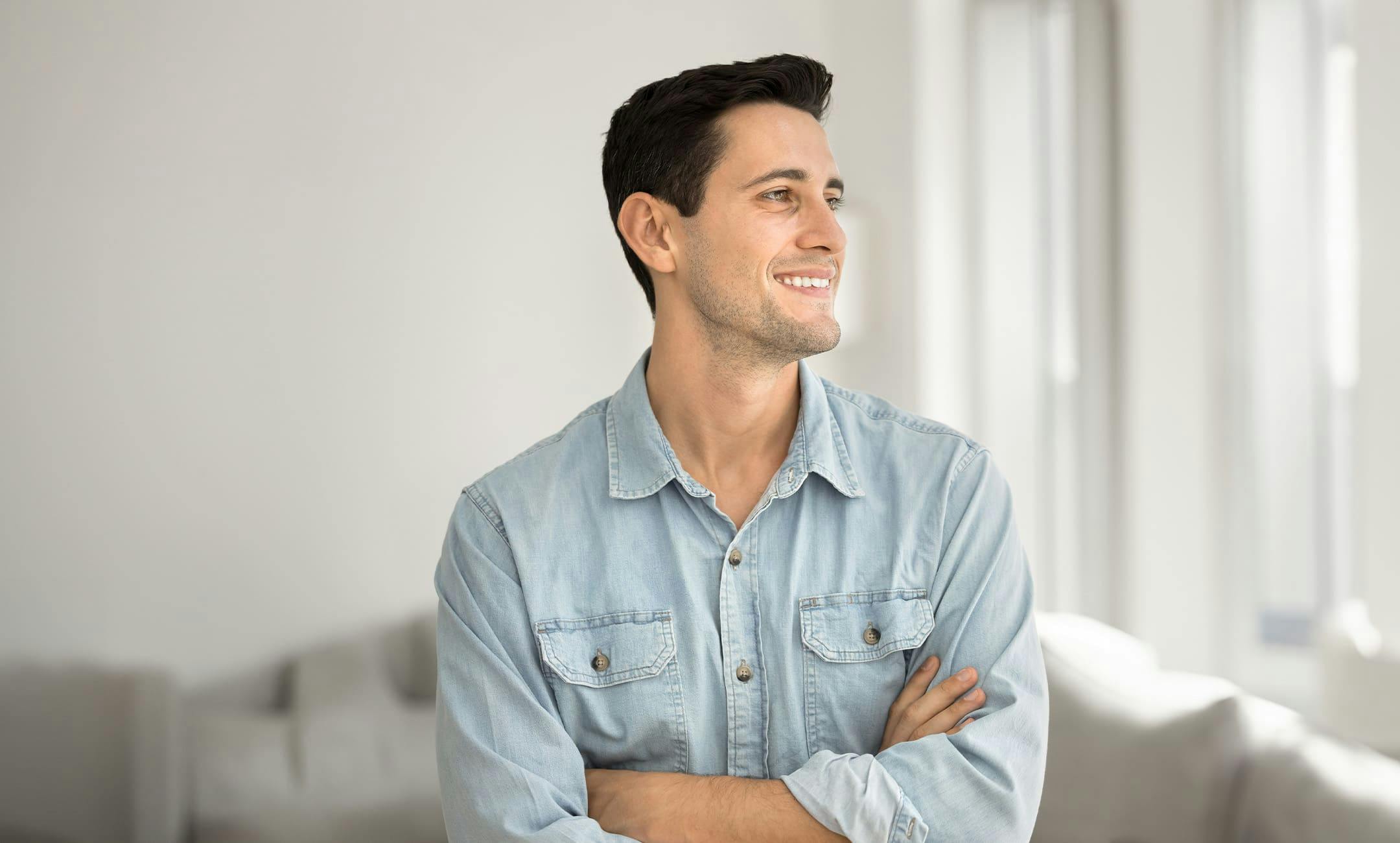 man smiling while crossing his arms