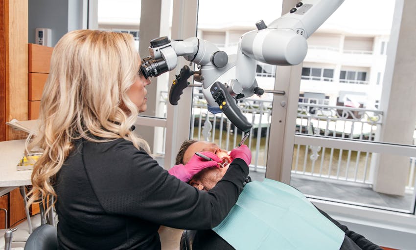 hygienist cleaning patient's teeth