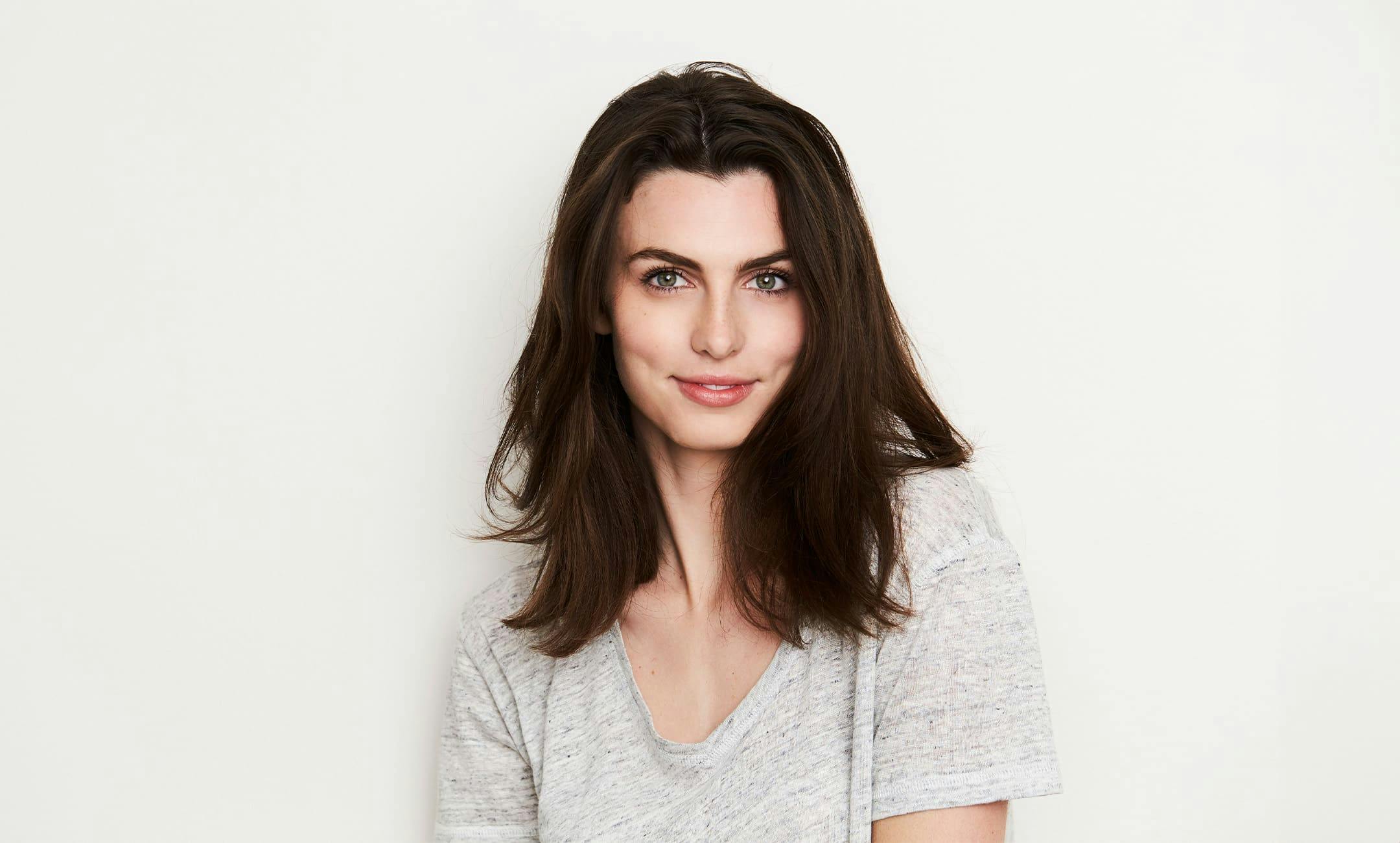 brunette woman smiling and looking forward