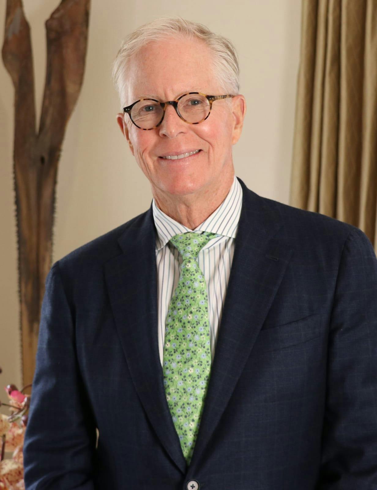 Portrait of Dr. Clifford P. Clark III in a suit with green tie, smiling