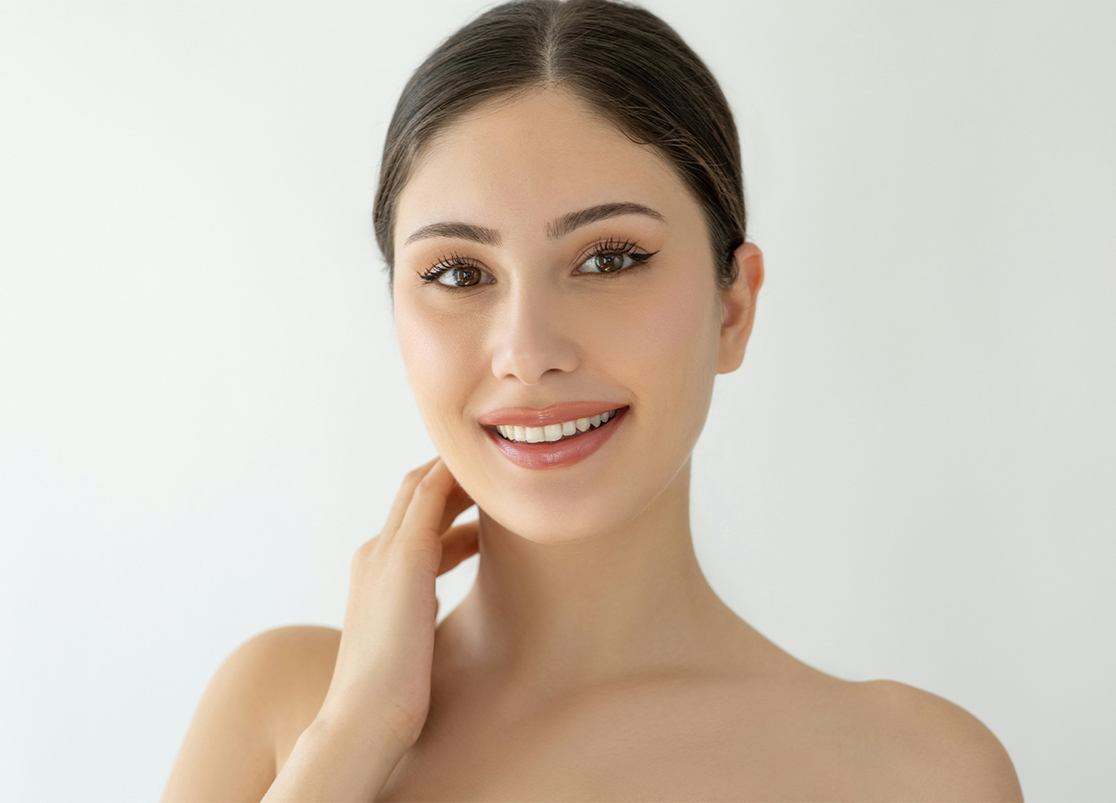 Woman smiling and touching neck