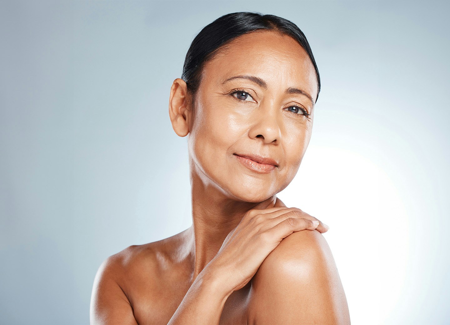 Woman smiling with hand on shoulder