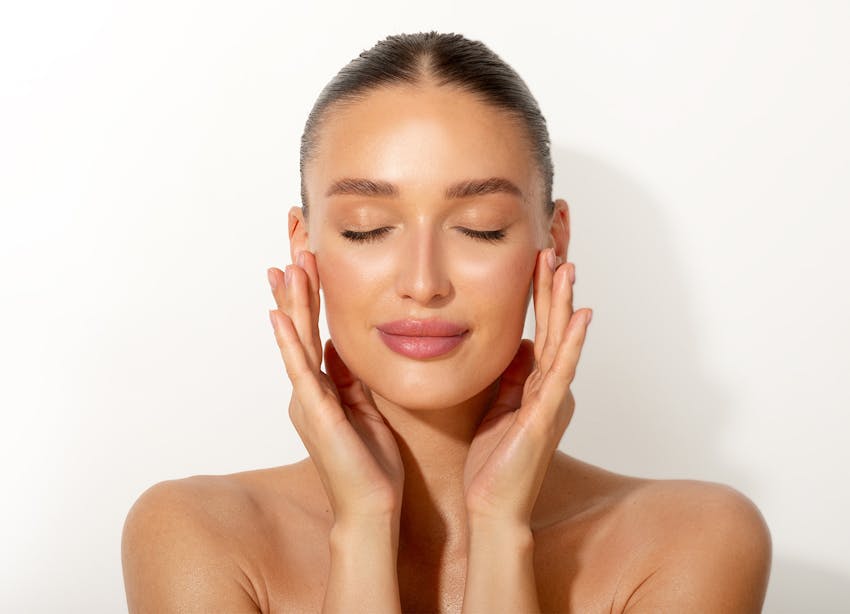 Woman closing eyes and touching face