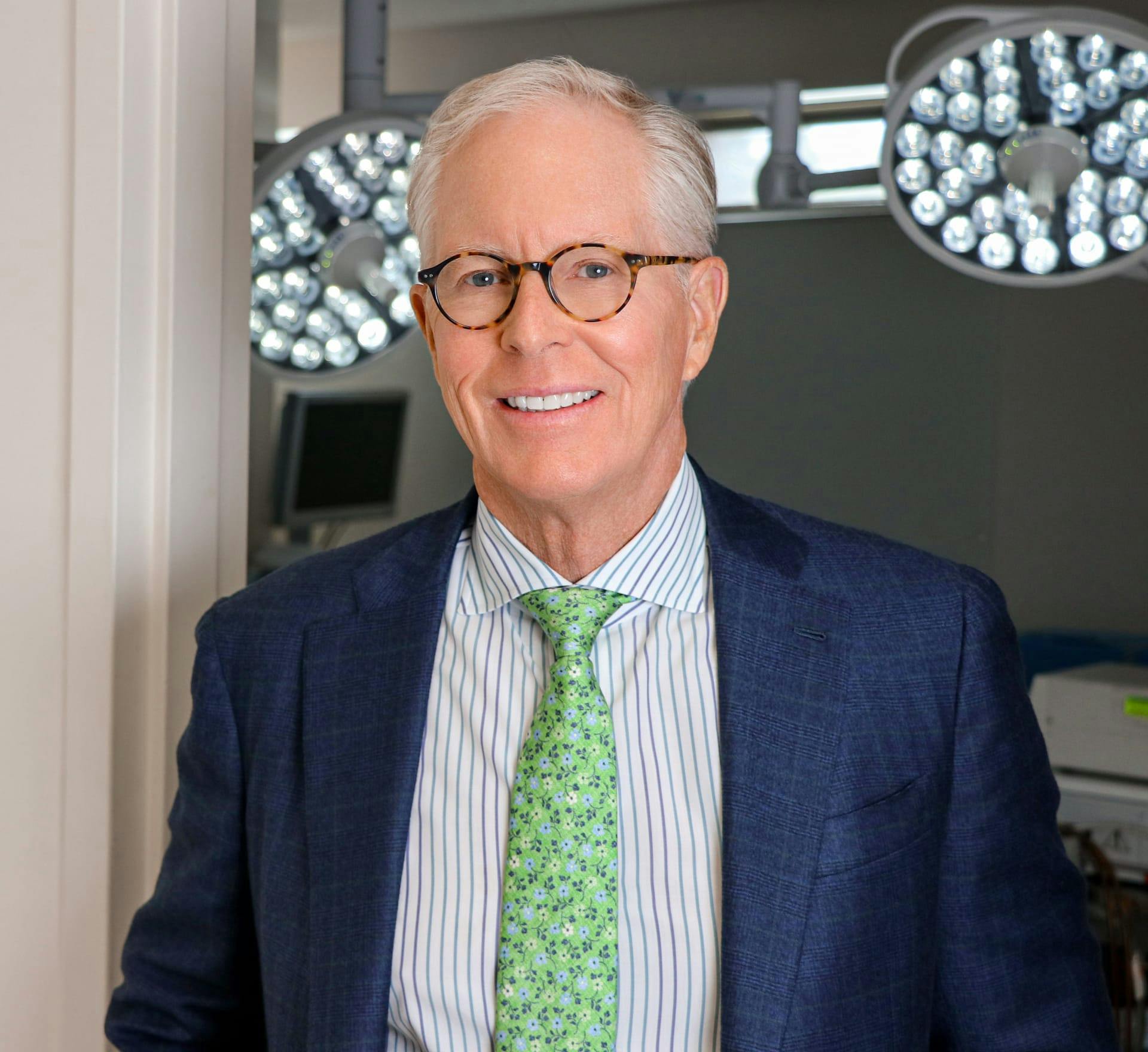 Dr. Clifford P. Clark in a navy suit and green tie