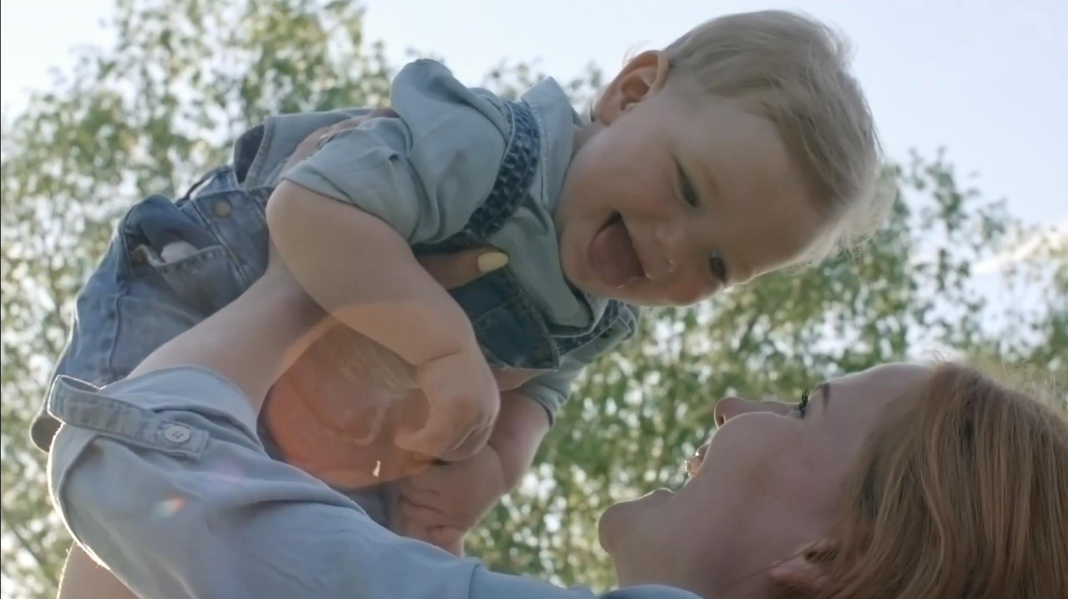 Mom Picking her smiling son up and overhead