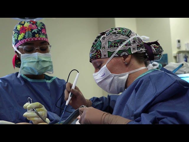 Dr operating with scrubs on and masks