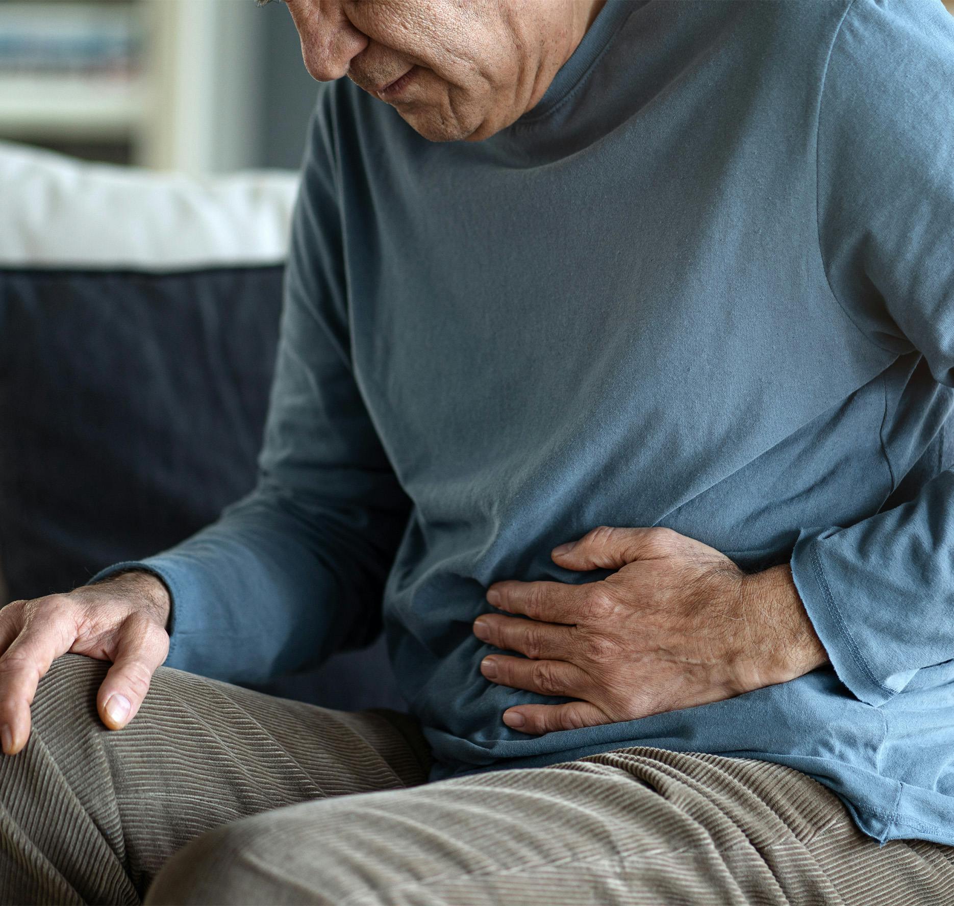 elderly man with hand on stomach