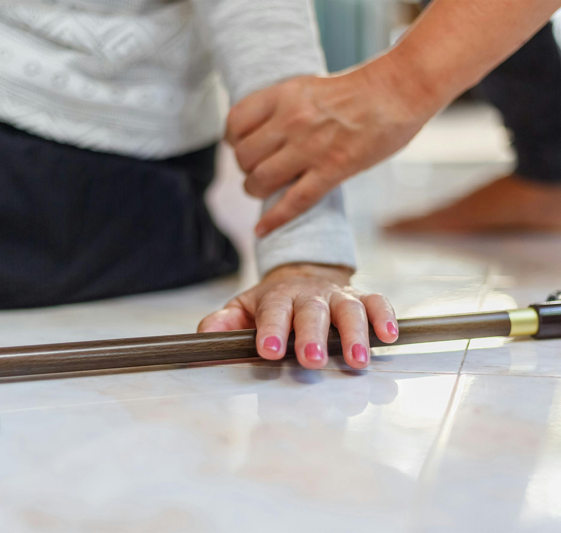 someone grabbing the hand of an ederly person post fall