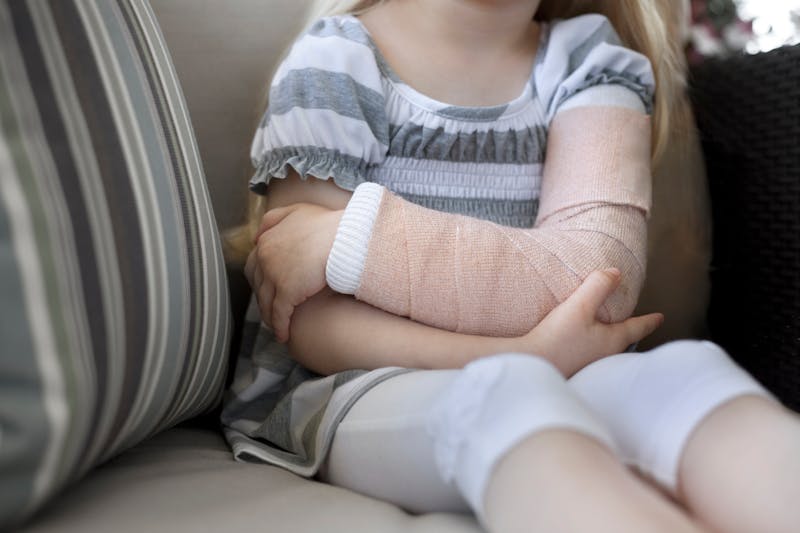 little girl wearing a cast on her arm
