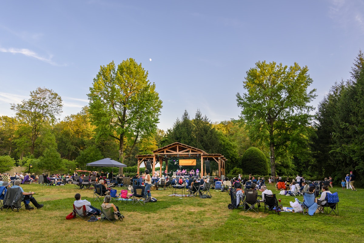 Outdoor music venue, patrons on the grass sitting in lawn chairs for summer concert