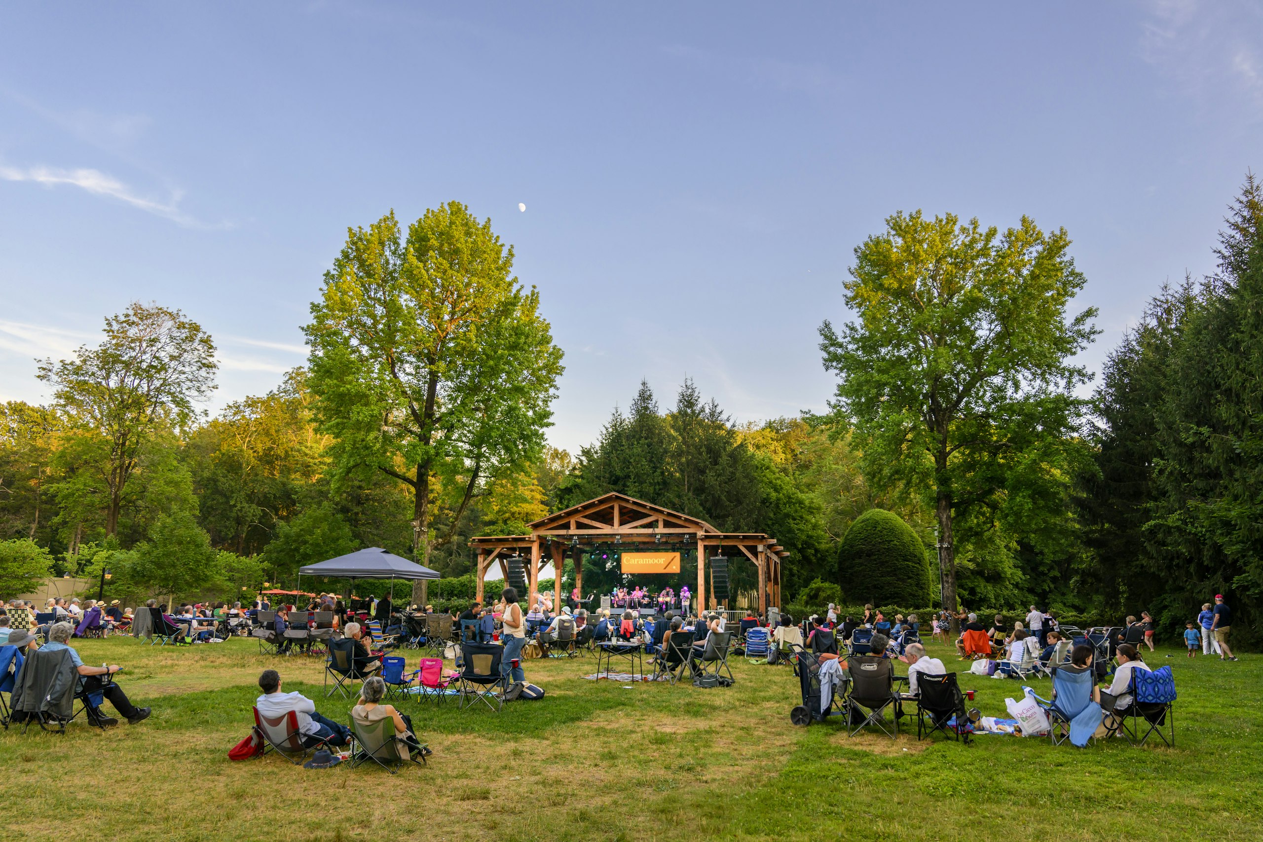 Outdoor music venue, patrons on the grass sitting in lawn chairs for summer concert