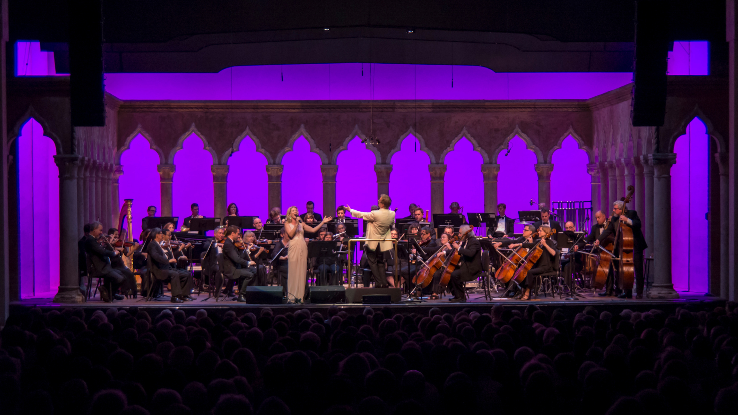 The Venetian Theater Stage is filled with 85 members of Orchestra of St. Luke's. Kelli O'Hara, the soloist, is singing in the center.