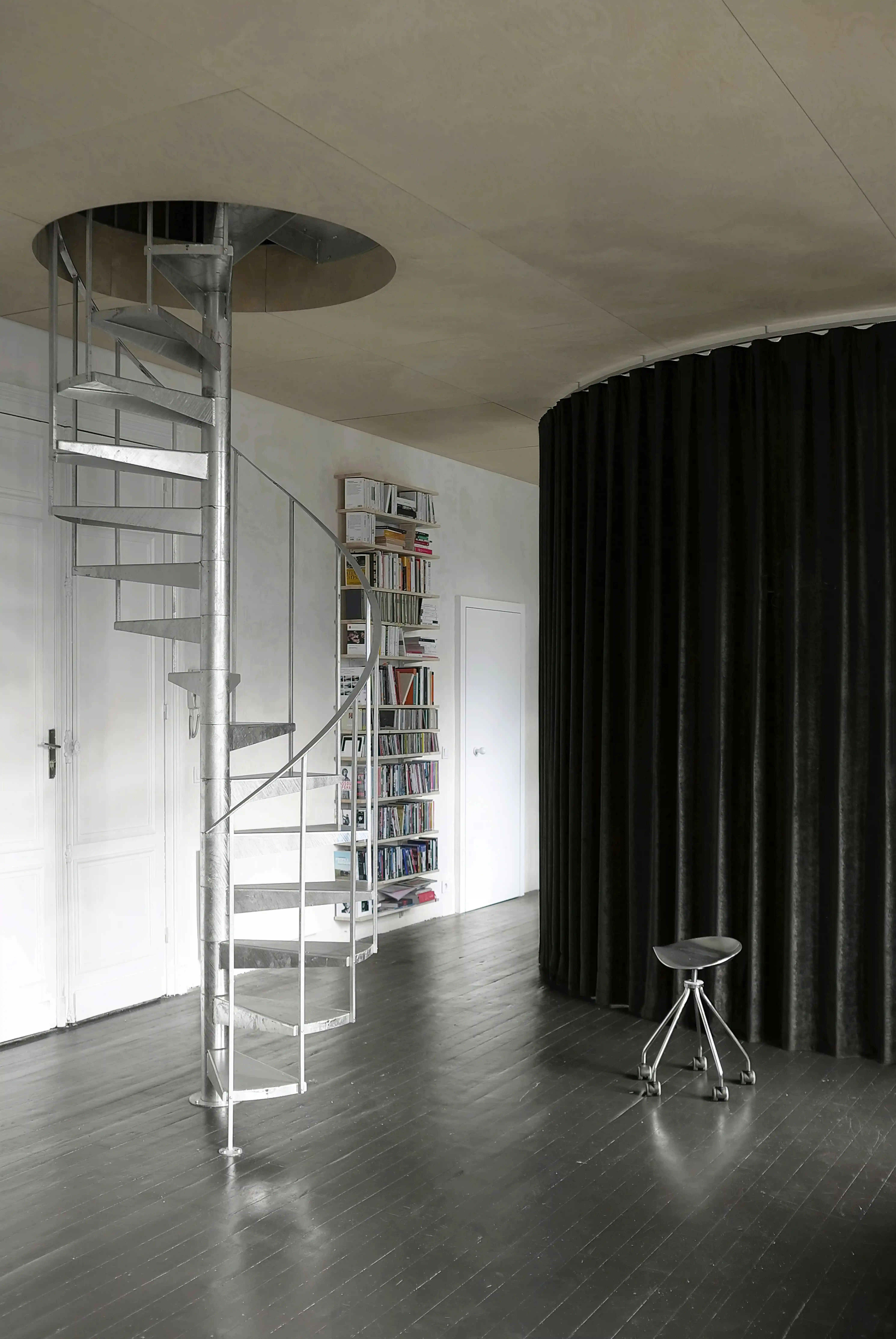 Photographie de l'escalier hélicoïdal en acier galvanisé et du rideau de velours noir