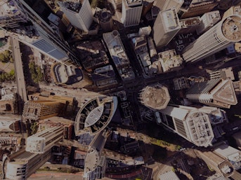An aerial view of multiple skyscrapers in a busy city on a sunny day
