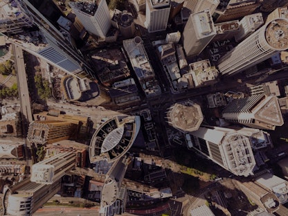 An aerial view of multiple skyscrapers in a busy city on a sunny day