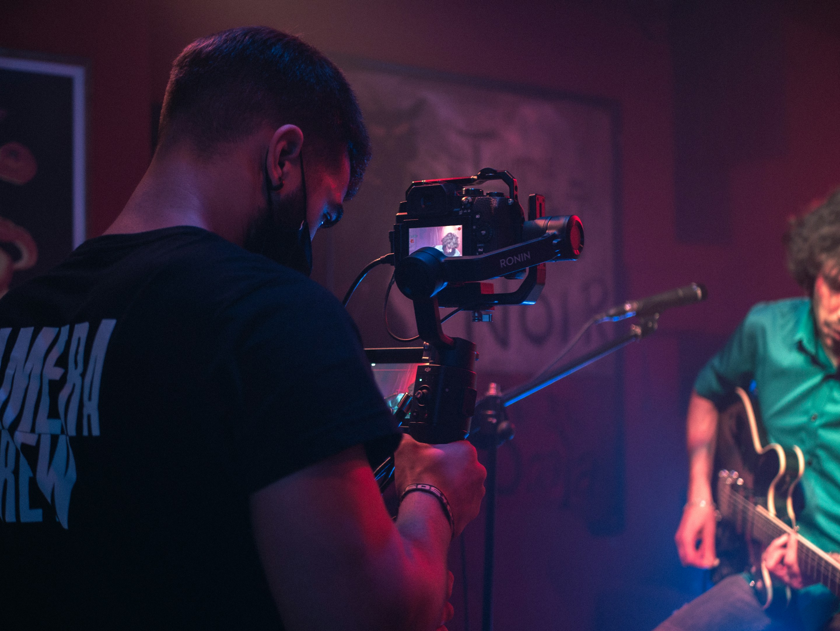 Videographer capturing a musician on camera as part of a creative production team