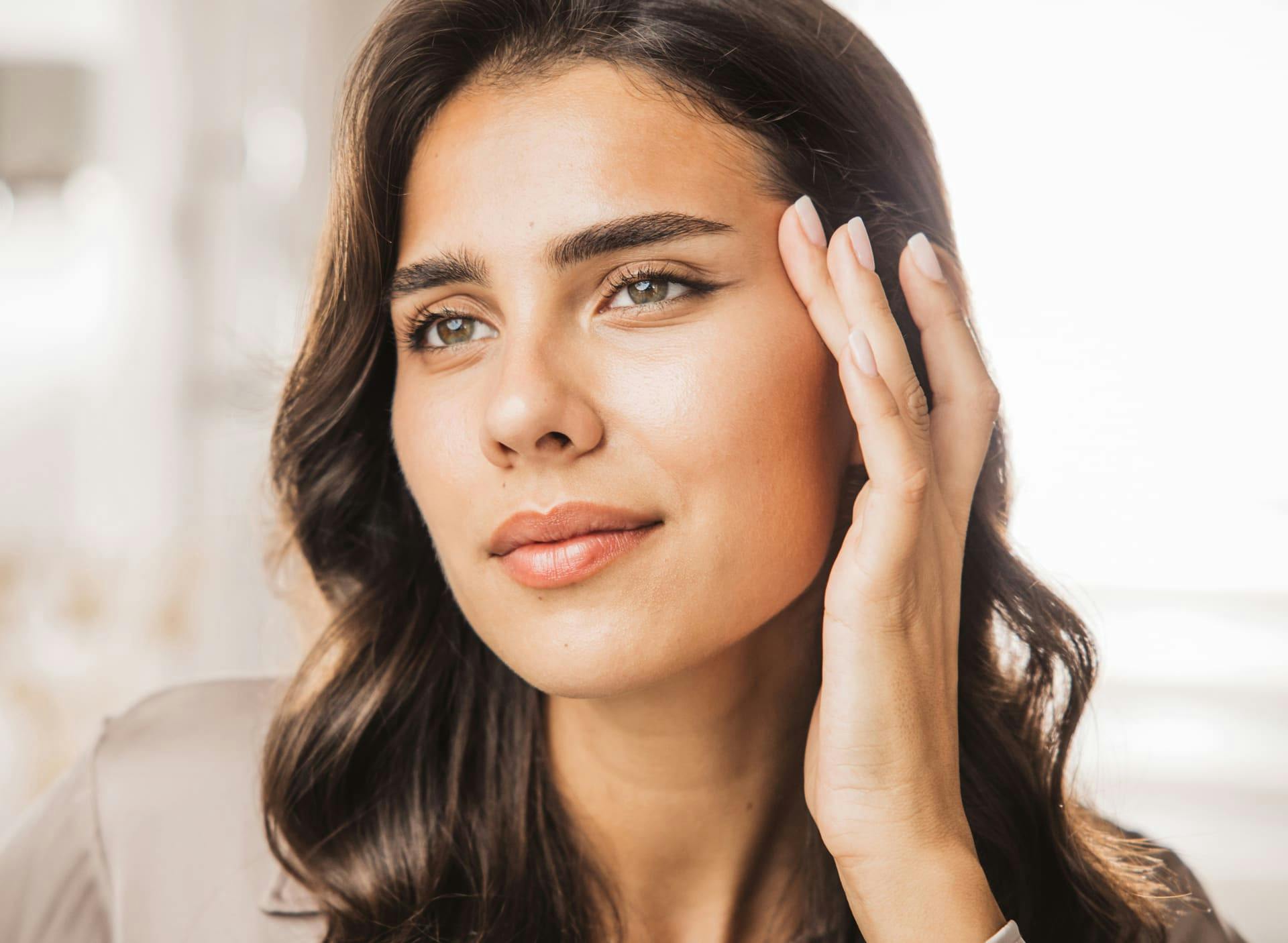 woman pulling her temple slightly, lifting her brow