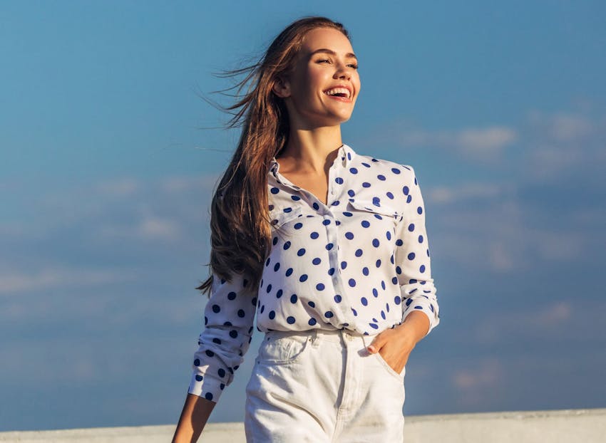 woman smiling in polka bot top