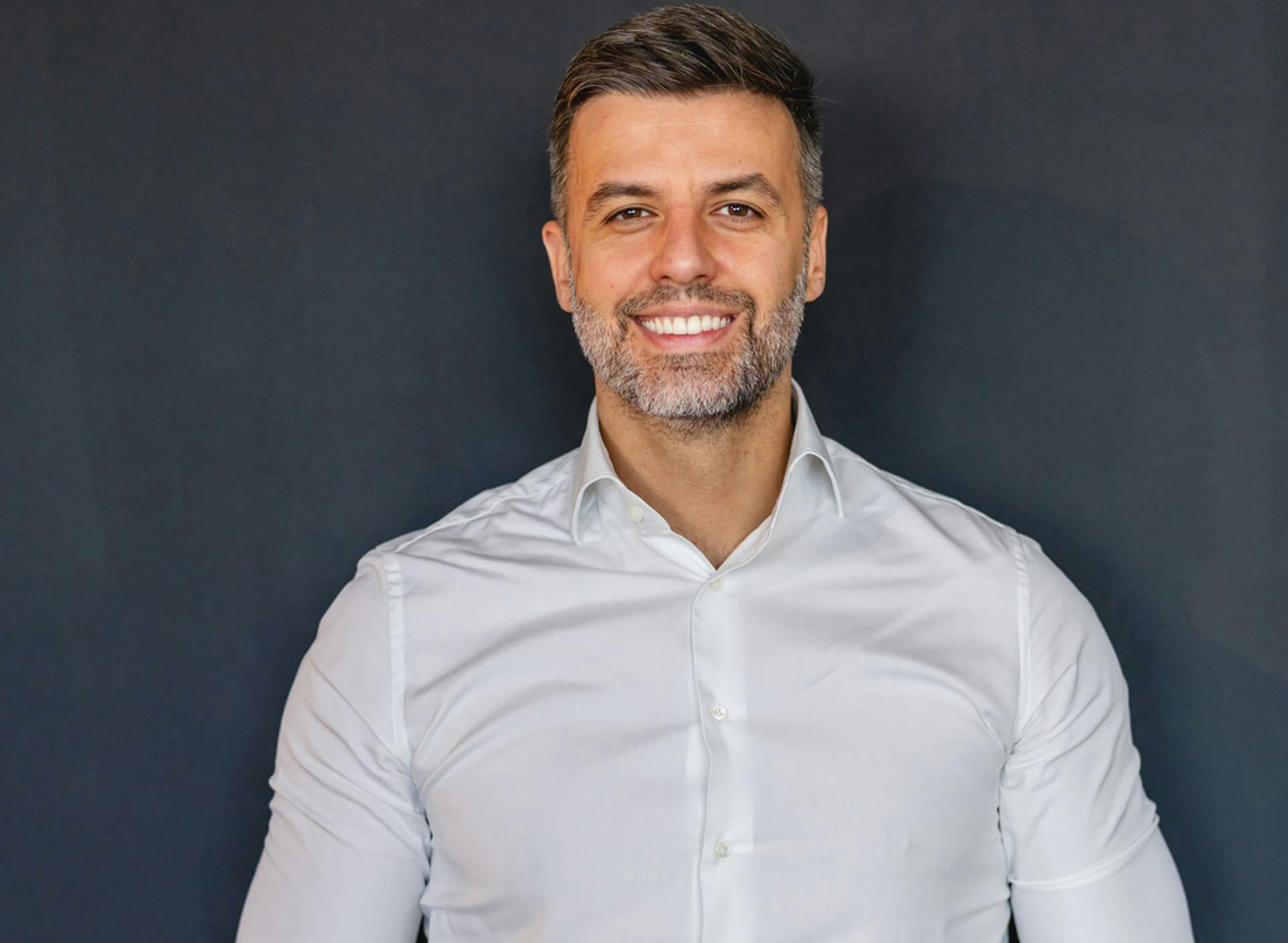 man smiling forward in white button-up