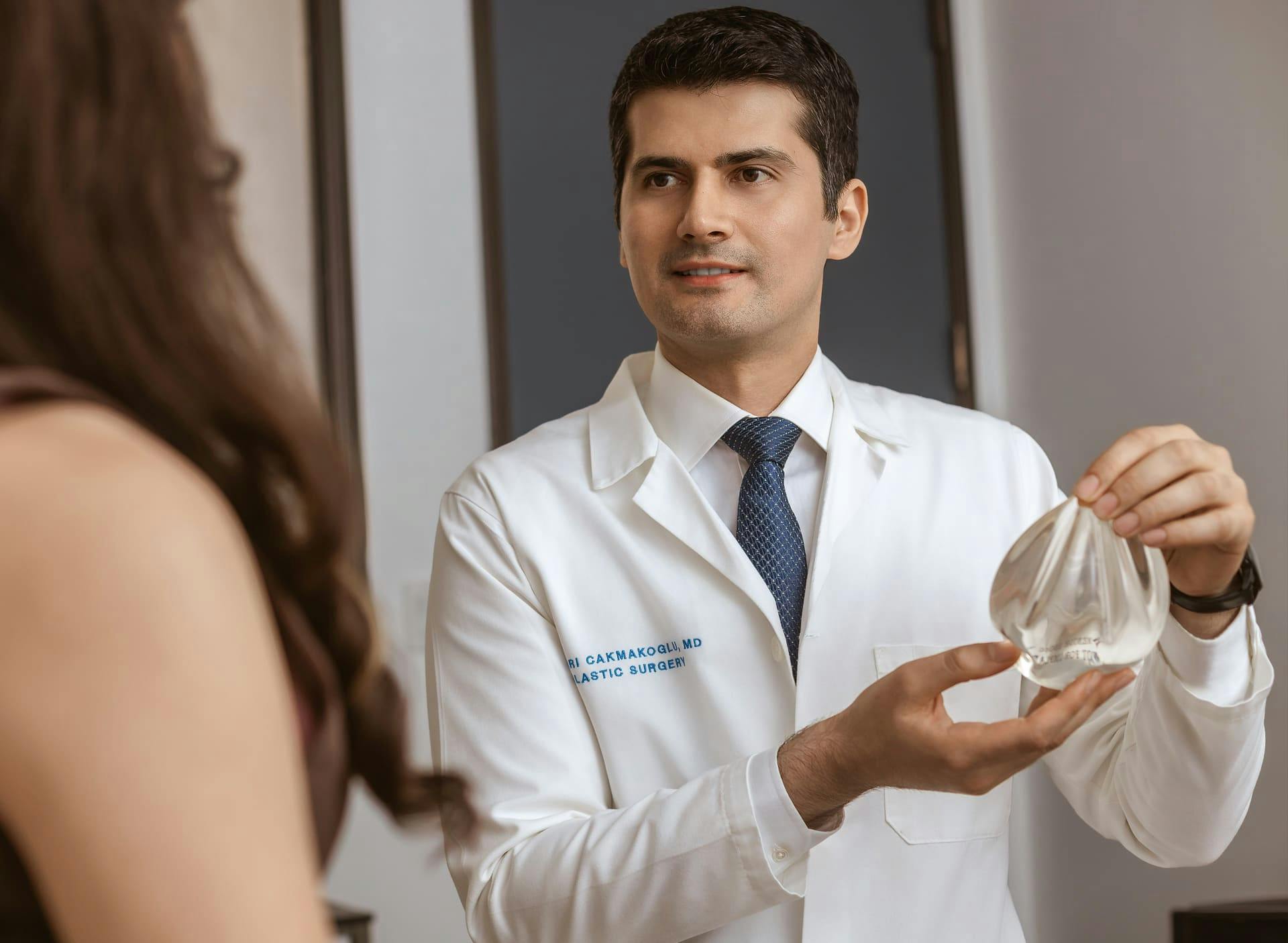 Dr. Cagri Cakmakogul showing implant to patient