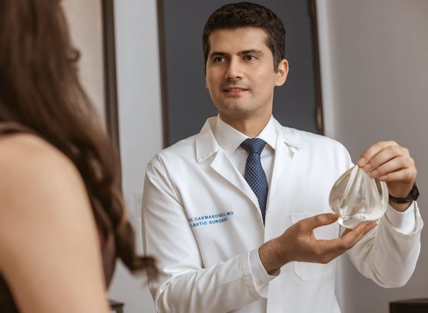Dr. Cagri Cakmakogul showing implant to patient