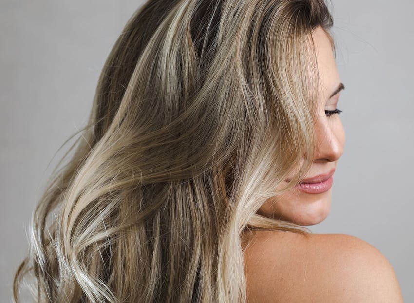 woman looking over her shoulder with her hair falling down
