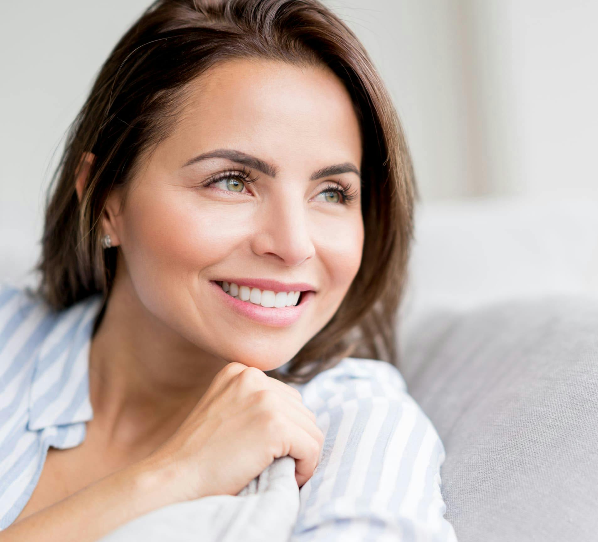 woman smiling and laying on the couch