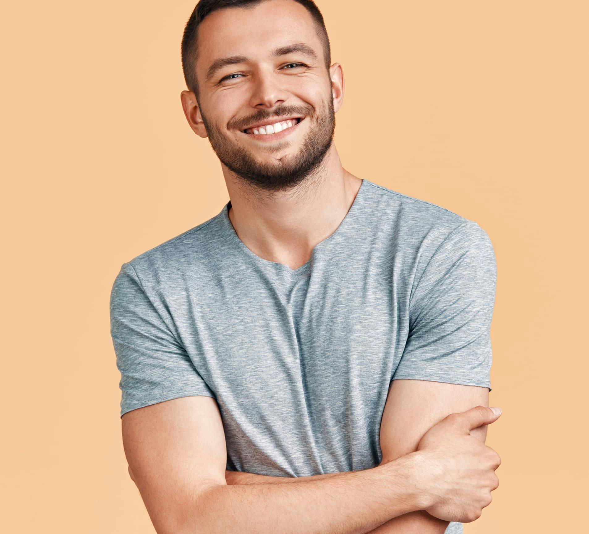 man smiling with his arms crossed